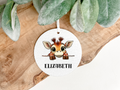 Circular Air freshener with a cartoon giraffe design anda  personalised name ,printed on both sides with a decorative ribbon