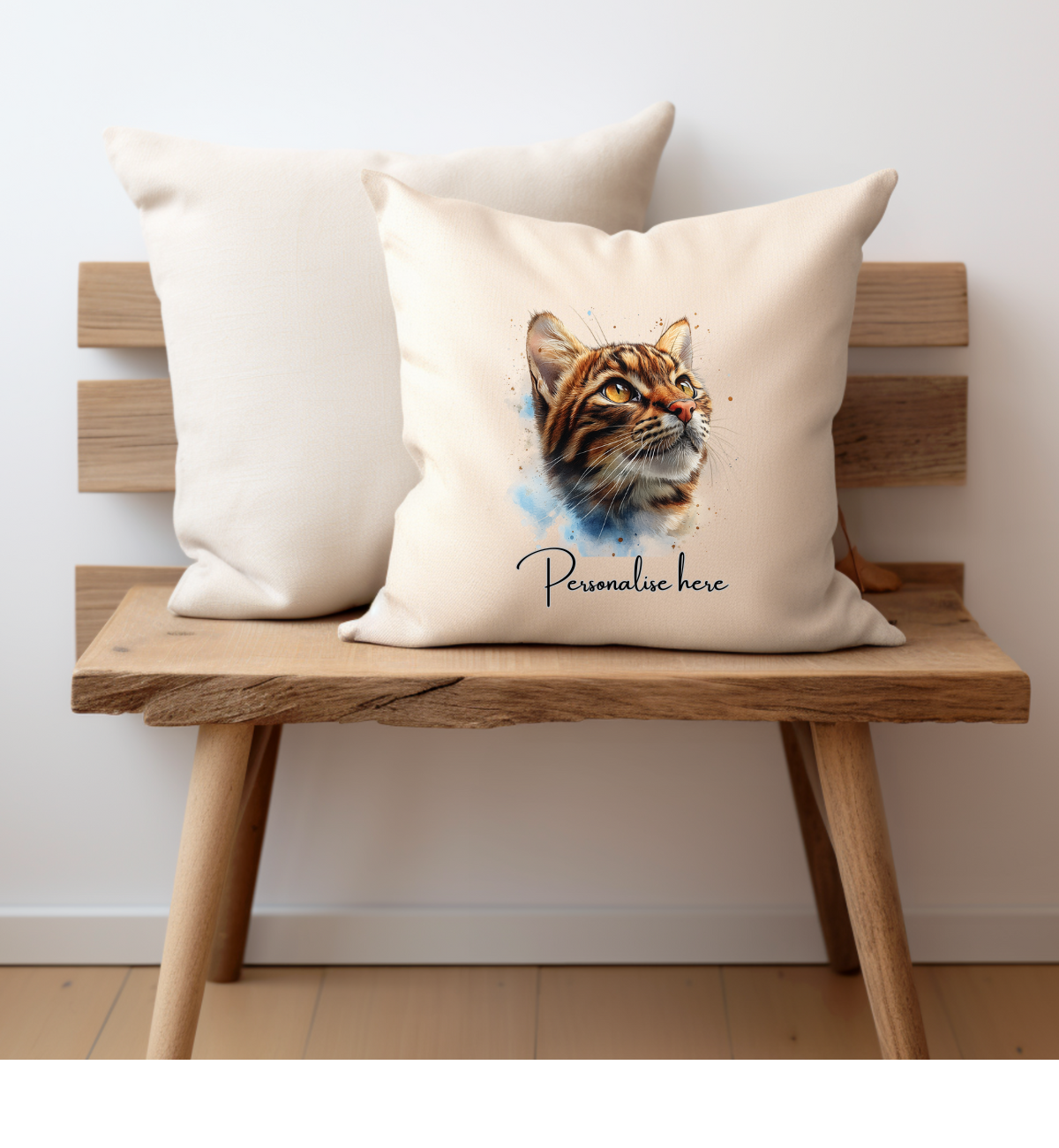 A cream cushion cover with a Bengal cat looking up printed on one side with a personalised name option, the cushion cover has a zip opening and is displayed on a small bench, the pet printing company cushion 