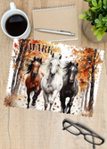 a rectangular glasses cleaner printed on one side with three horses running through the autumn woods and personalised with a name