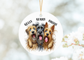 a 7cm aluminium ornament printed on both sides with three mongrel dogs with their paws around each other, each dog ahs a personalised name above its head the ornament is hung with a random decorative ribbon
