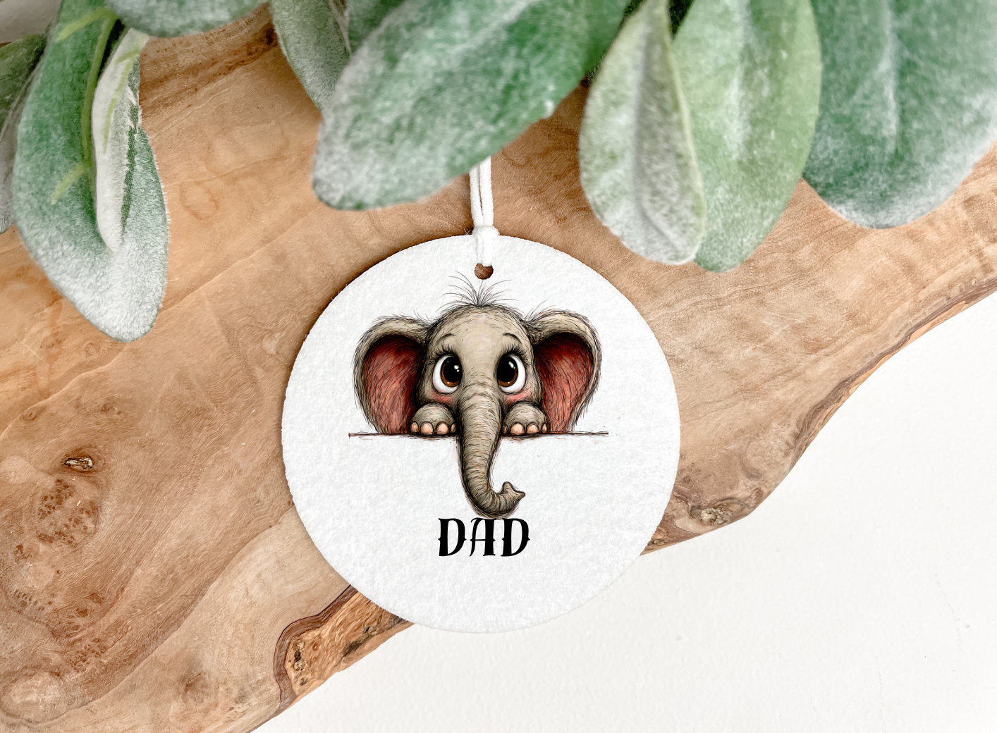 A baby elephant in cartoon style printed  onto a round soft air freshener 8cm diameter  with a hanging ribbon and personalised with a name the pet printing company